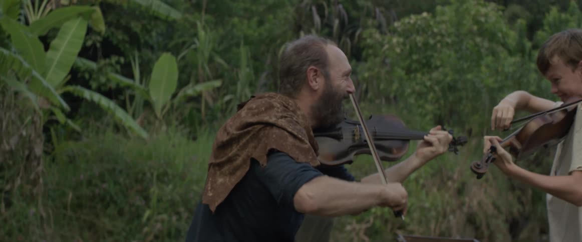 Man and young boy each play a violin