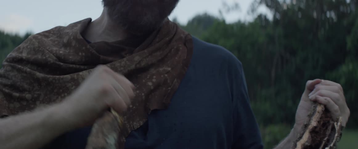 A man splits a piece of wood in half with his hands
