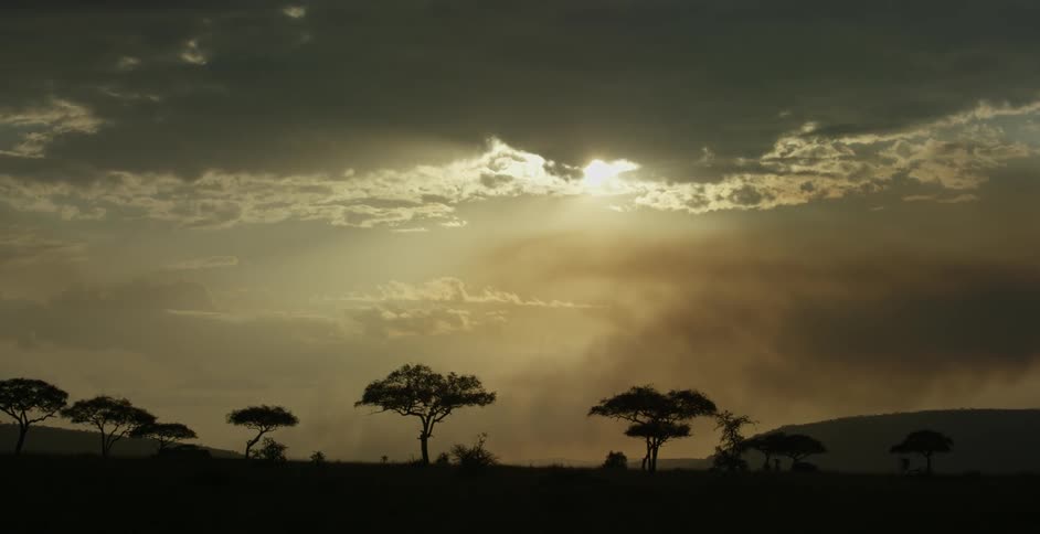 The sun is peeking through the clouds at sunset