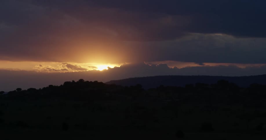 The sun sets above a hill