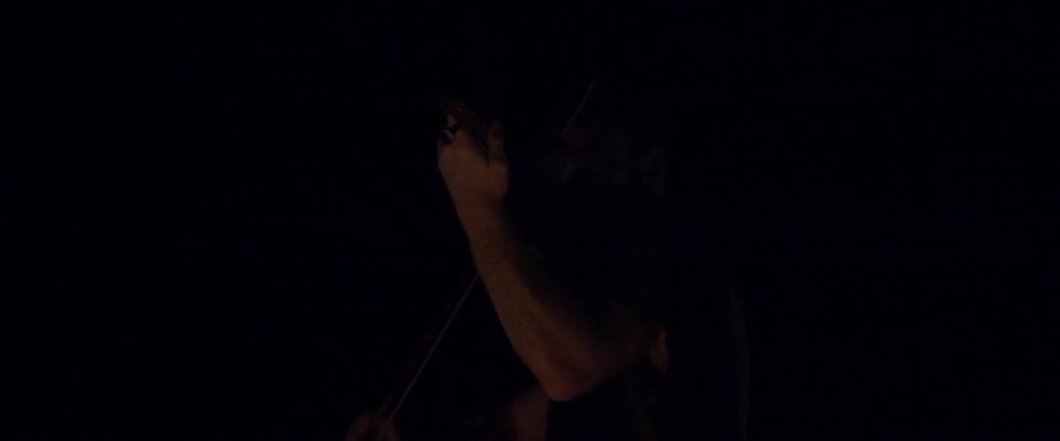 A man is playing an instrument in a cave