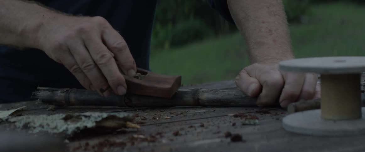 A man sands a piece of wood
