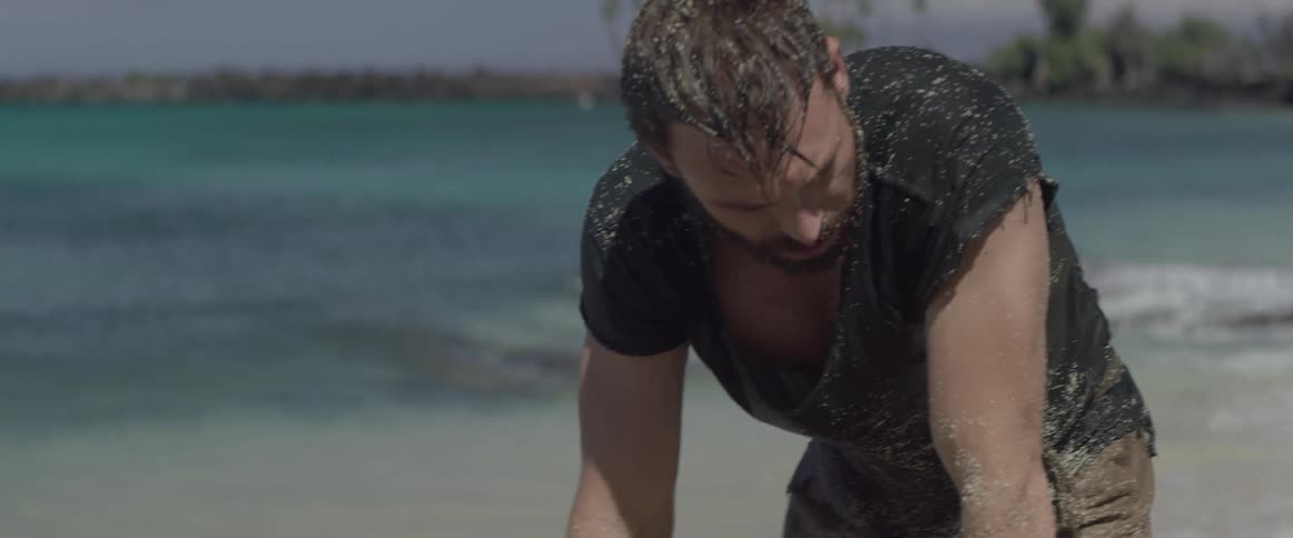 A man getting down on his hands and knees at the beach