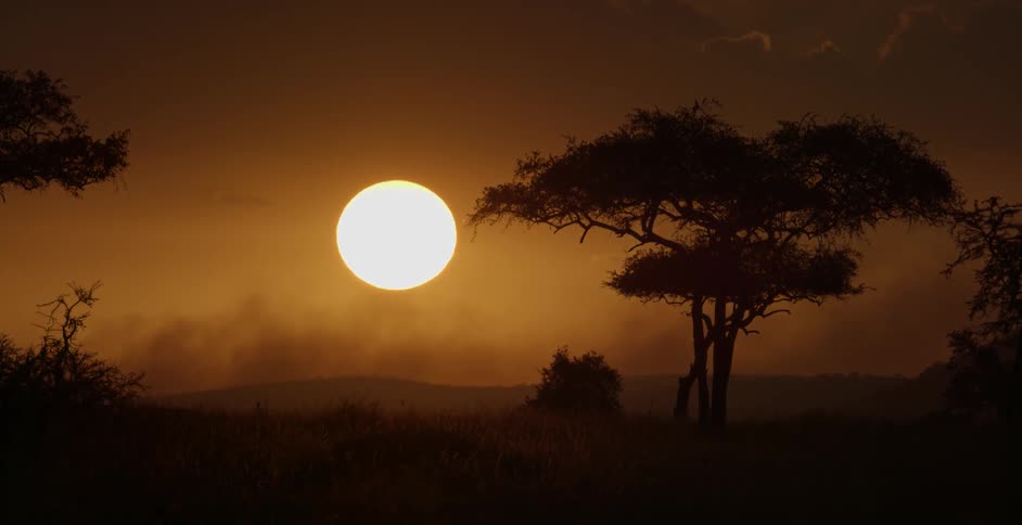 The sun sets in the hazy sky