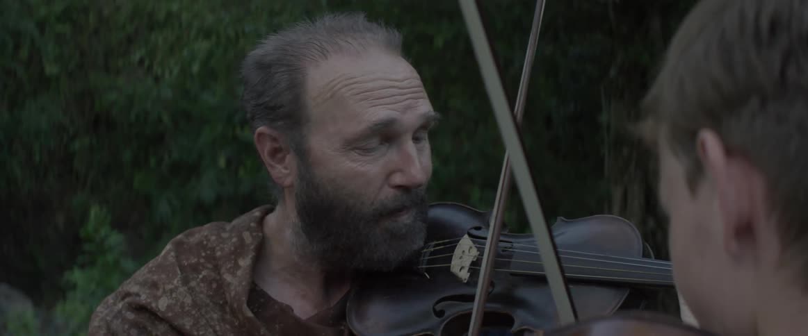 A man is teaching a boy how to play the violin