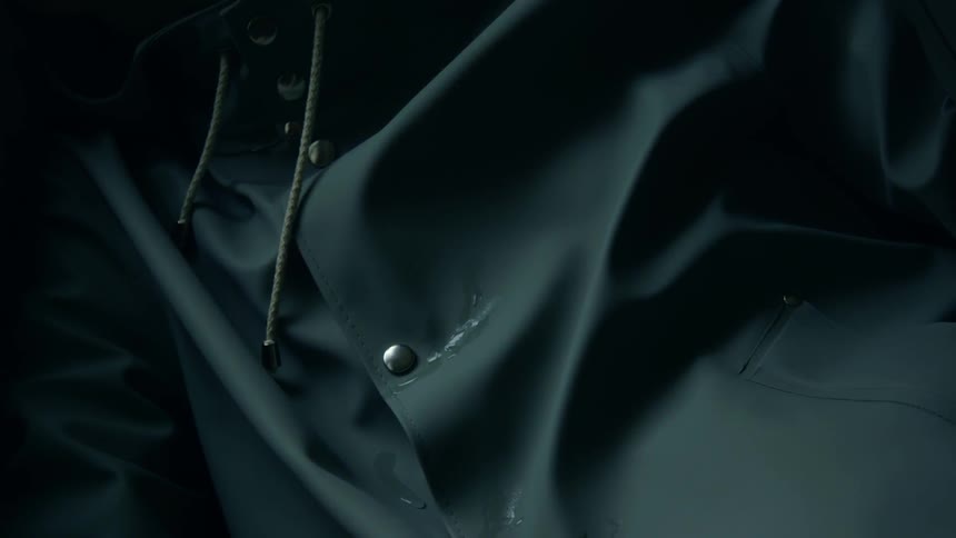 Droplets of water run down the front of a rain jacket
