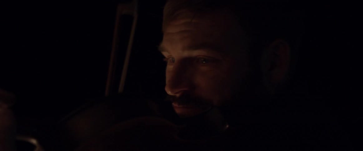 A man plays violin outside at night