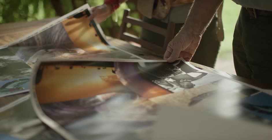 A man and woman look at printed posters on a table