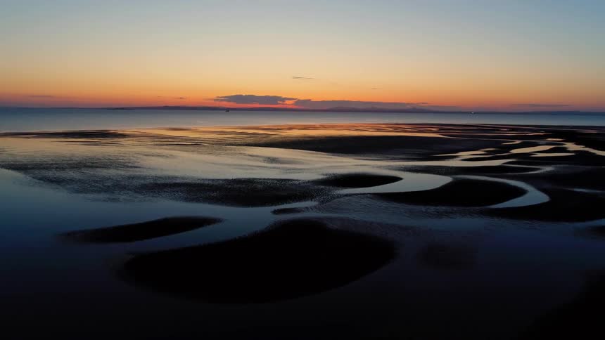 A watery beach at sunset