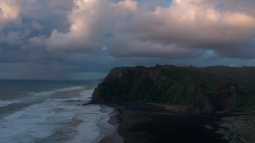 Ocean waves wash ashore a beach at sunset