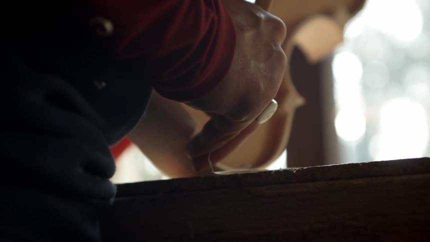 A man crafts a violin by hand