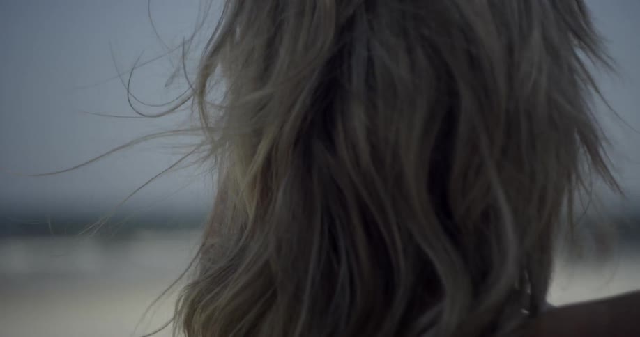 Woman's long blond hair blows in the breeze