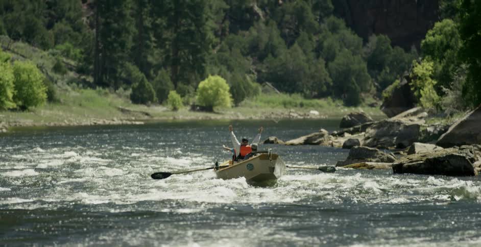 People are rowing a boat down the rapids ahead