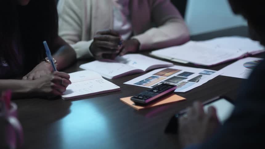 Workers in an office work together at a table