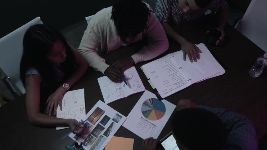 People sitting at a table and studying papers