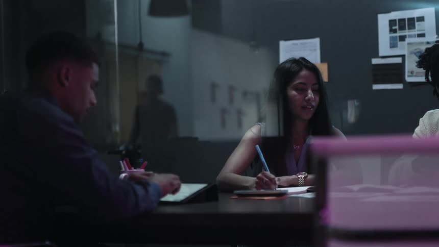 Workers sit at a table and work together