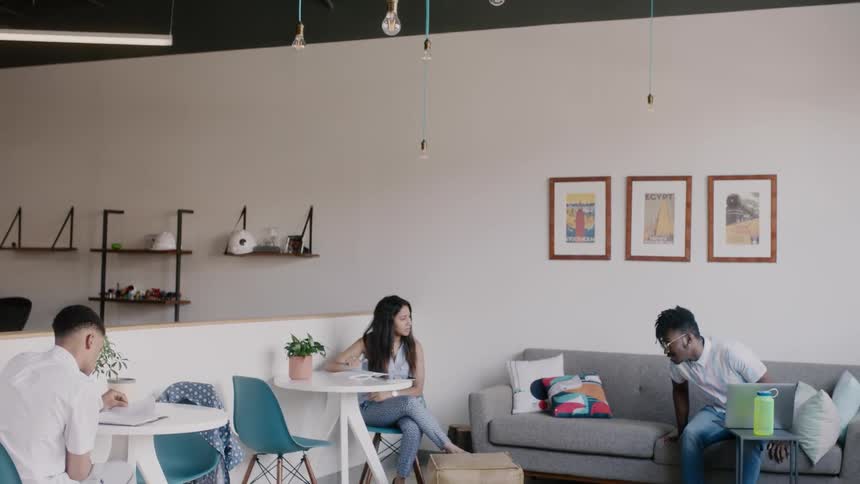 Young people are sitting around in a casual setting working on things