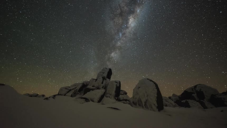 Stars and a galaxy pass by overhead on a clear night