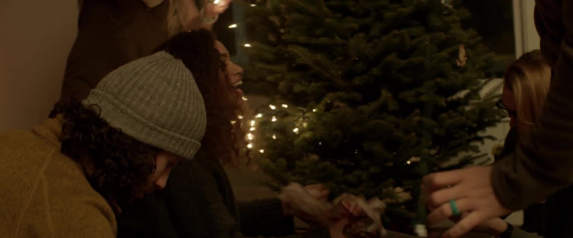 People string lights onto a christmas tree