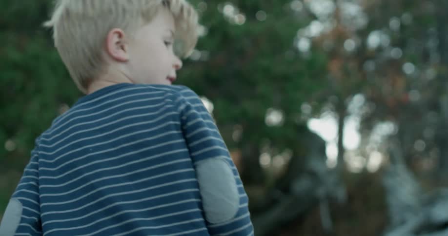 A young boy plays outside