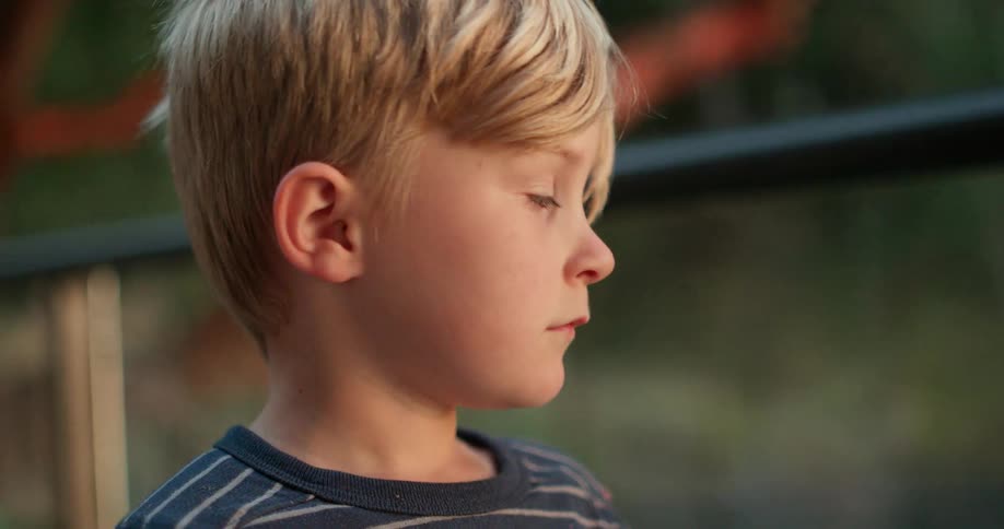 A boy is covering his face