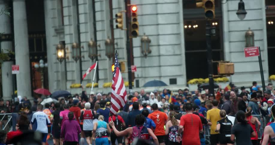 A person holds a flag as they run a marathon in a city