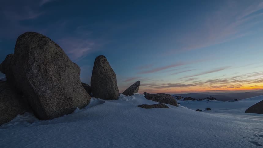 Rocks in a snow covered area at sunset