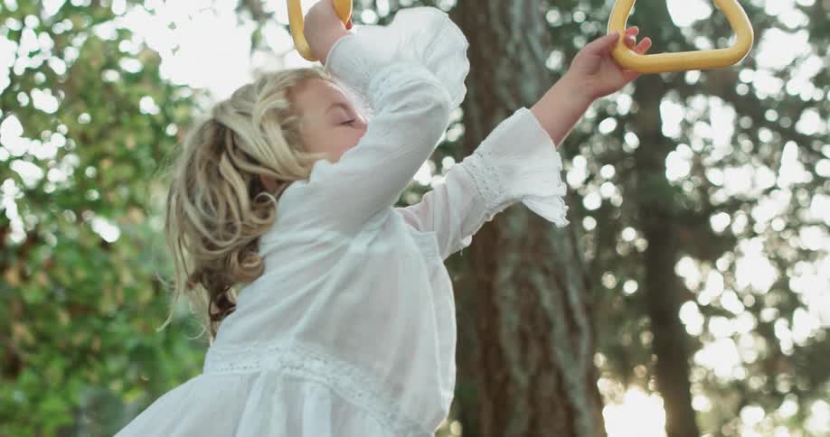 A young girl plays with climbing hoops outside