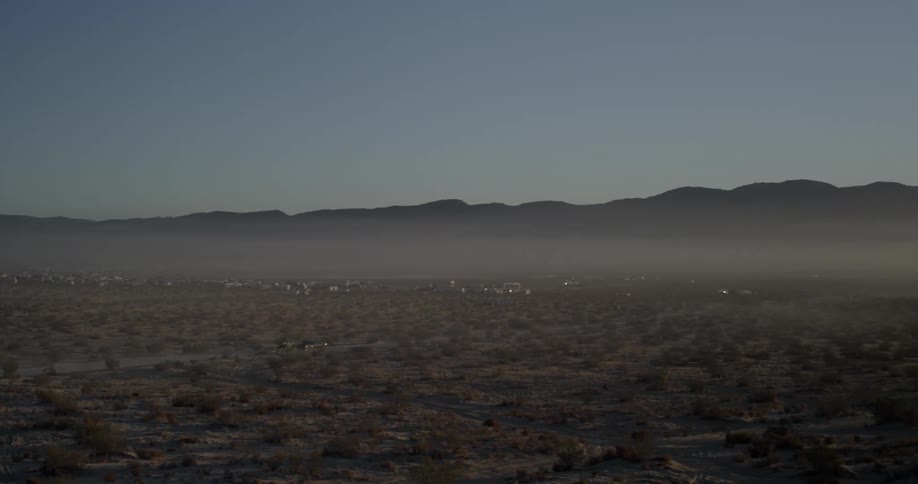 Cars drive across a desert road