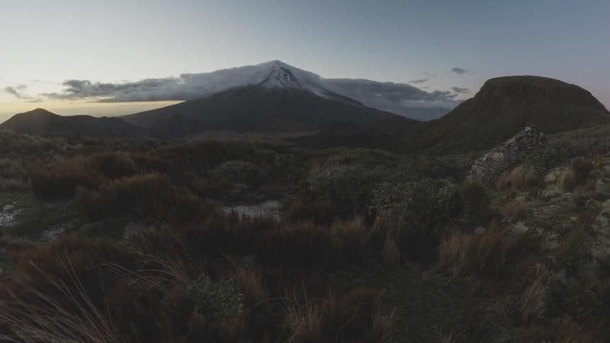 Time lapse view of sunrise over distant mountain with billowing clouds