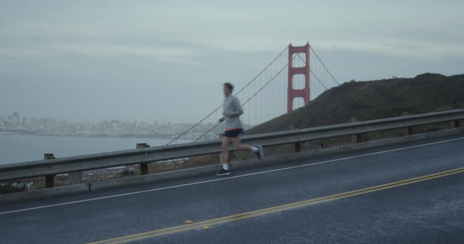 Man jogs down a road on a cloudy day