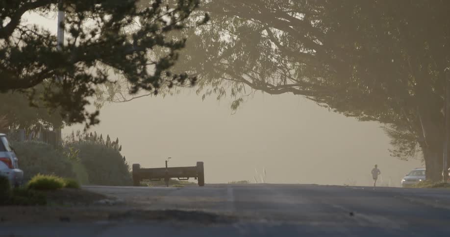 Man jogs down road and a car passes