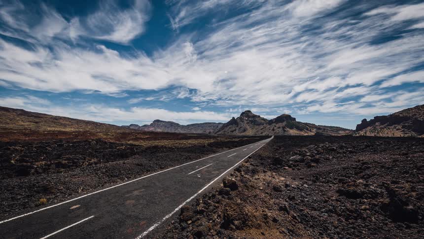 The clouds move quickly over the empty road