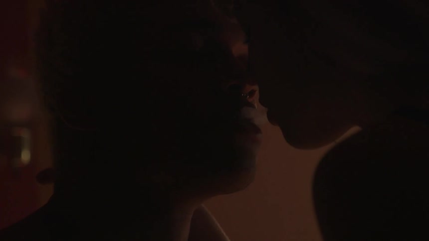 A woman is blowing smoke into a man's mouth