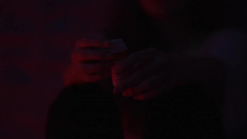 Person's hands in dimly lit room