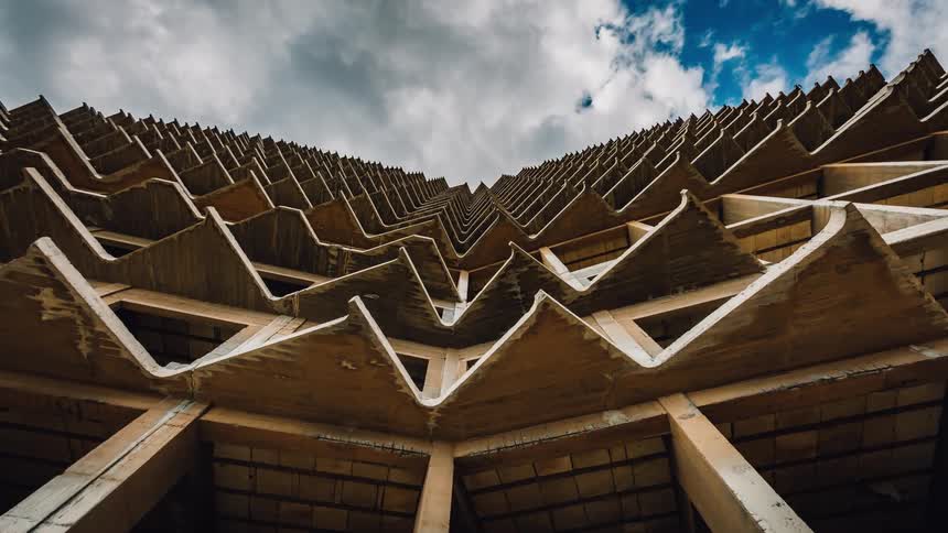 Clouds pass above an high rise structure during the day