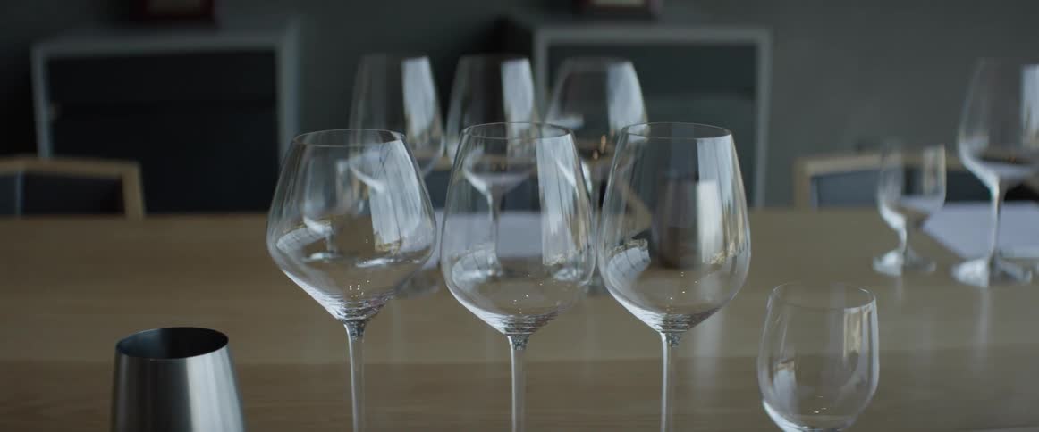 Several glasses on a large wooden table