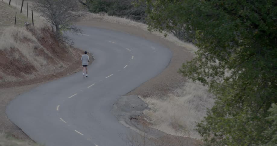 Man jogs down a winding road