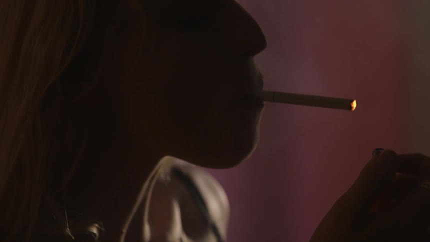 A woman lights a cigarette