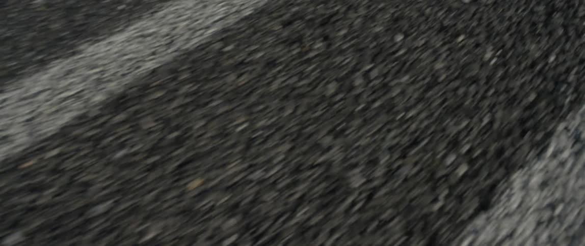 A close up shot of the road as a car travels over it