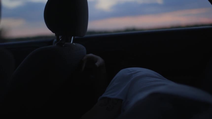 A person sleeping in the back of a vehicle
