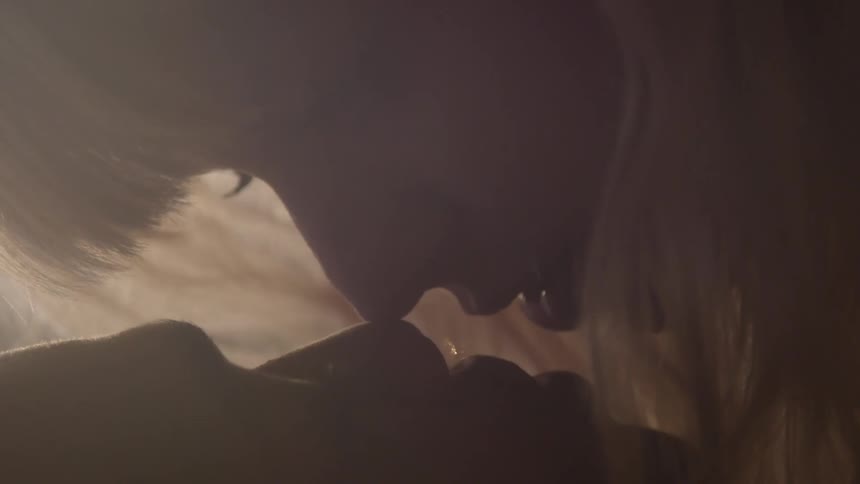 A man and woman embrace and almost kiss