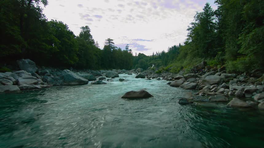 A drone is flying low over a stream