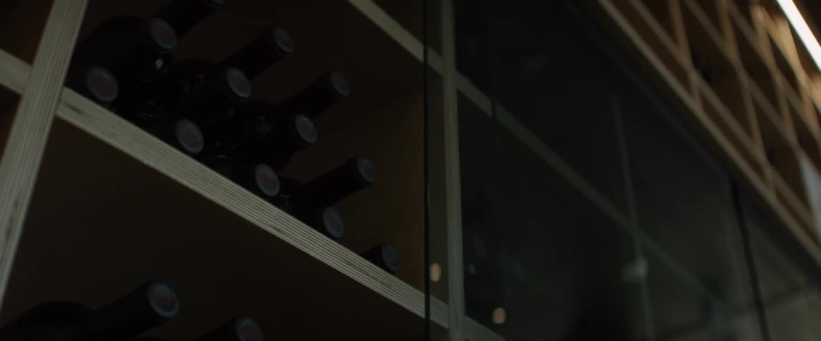Bottles of wine sit on shelves in a cellar