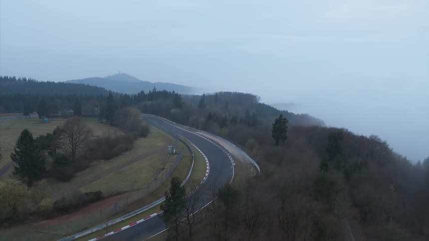 A road winds through a forest on a rural hilltop