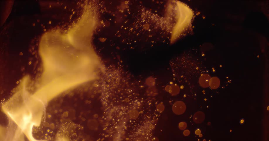 Flames are burning and casting sparks into the darkness