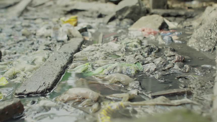Water ripples around trash on the ground