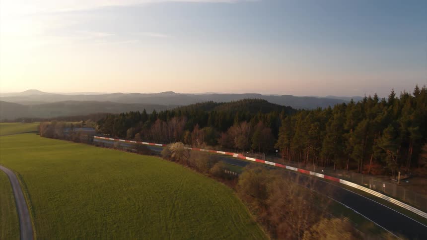 A race course is being filmed by a drone at dawn