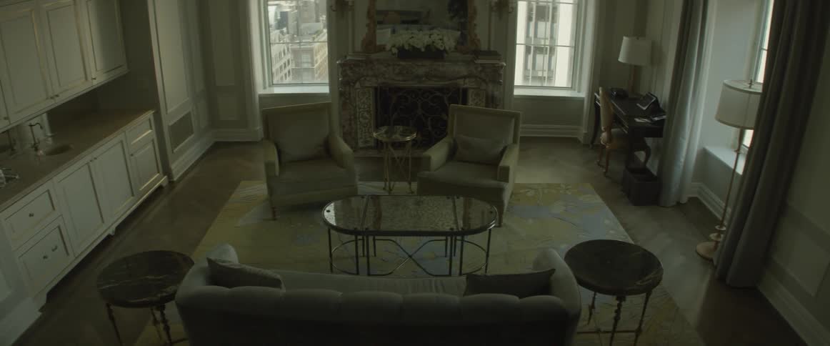 An empty living room is filmed from the stairs