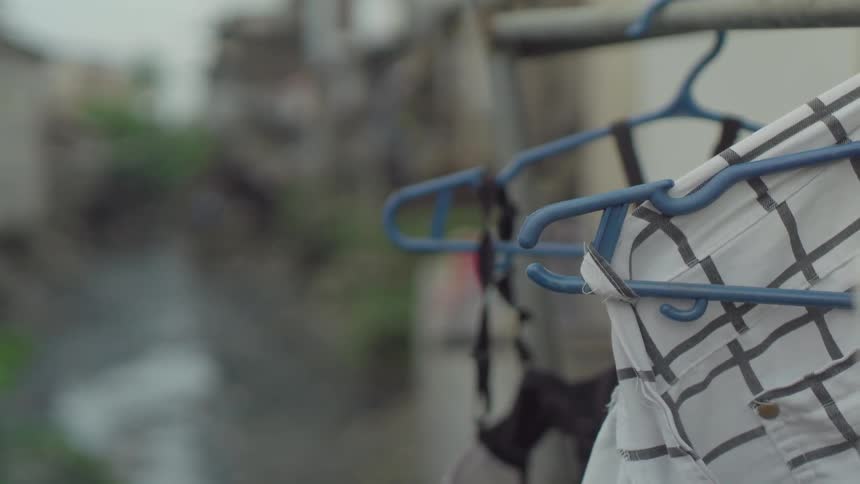Plastic hangers hold clothes outside of houses